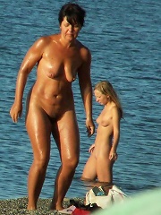 Young nudist friends naked together at the beach